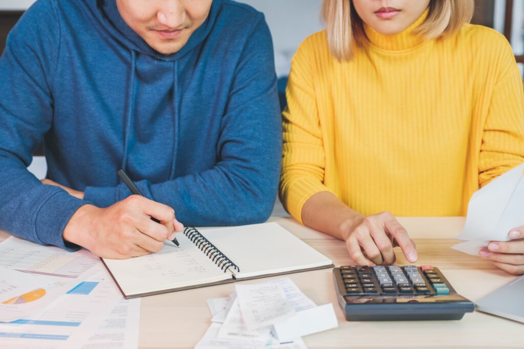 Close up Asian couple list home financial bill budget on table